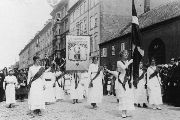 Historisk foto af kvindeoptog med banner og Dannebrog