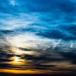 Dramatisk aftenhimmel med solnedgang bag skyer