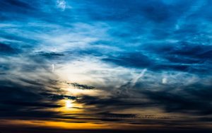 Dramatisk aftenhimmel med solnedgang bag skyer