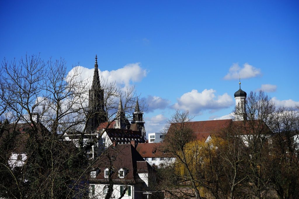 Kirketårne og spir over bytage mod blå himmel