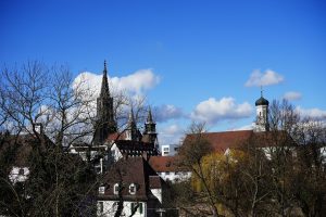 Kirketårne og spir over bytage mod blå himmel