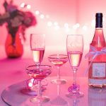 Rosévin og fyldte glas i lyserødt festlys