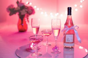 Rosévin og fyldte glas i lyserødt festlys