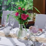 Dækket festbord med pink blomster i glasvase
