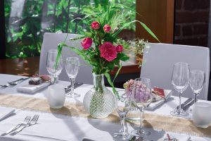 Dækket festbord med pink blomster i glasvase