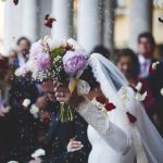 Brud med pæonbuket mens der kastes blomsterblade