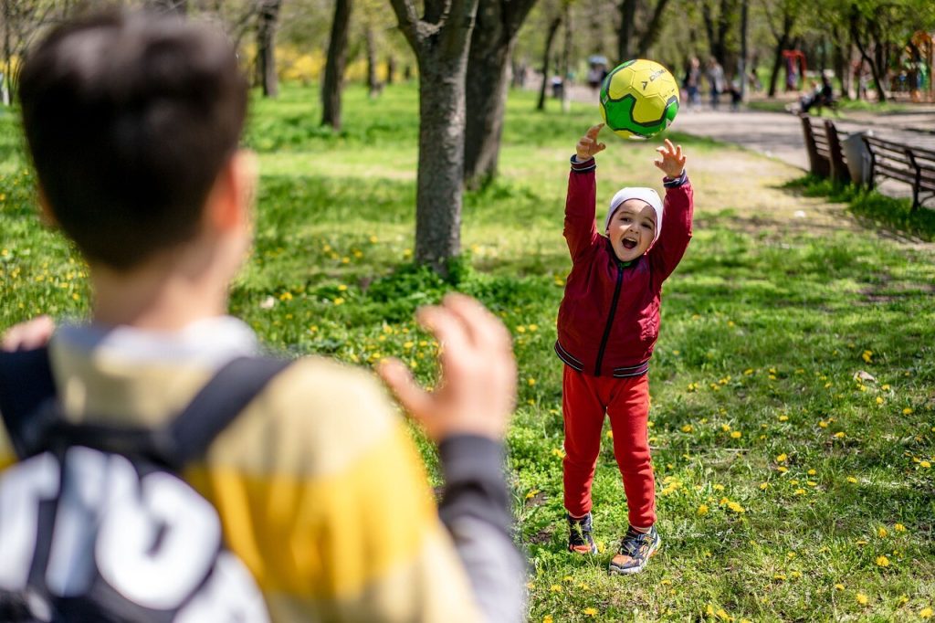 Børn kaster bold i parken