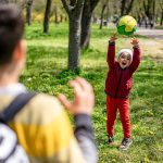 Børn kaster bold i parken