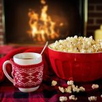 Popcorn og varm drik foran pejsen