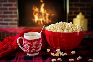 Popcorn og varm drik foran pejsen