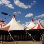 Rød-hvide cirkustelte under blå himmel