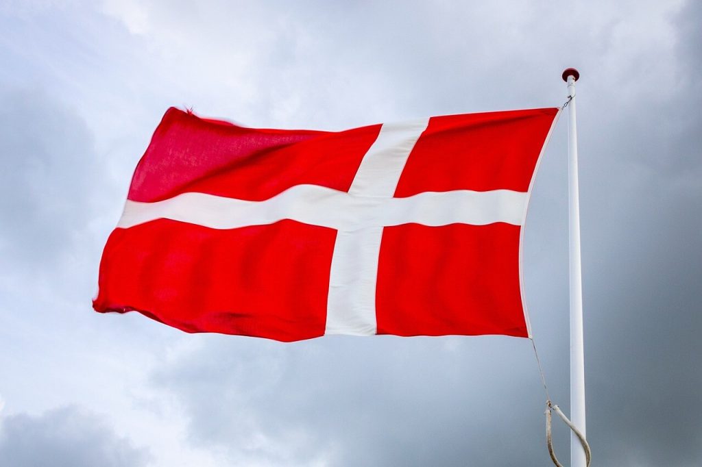 Et dansk flag der blæser på toppen af en flagstang