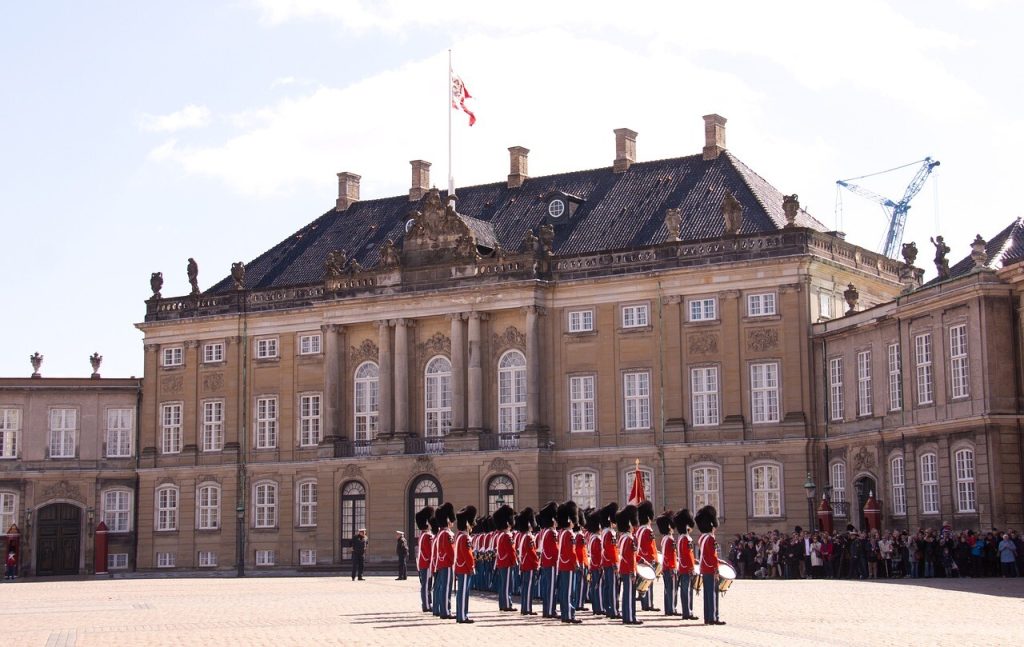Garder i røde uniformer foran Amalienborg