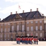 Garder i røde uniformer foran Amalienborg