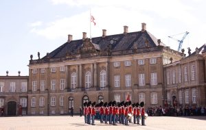 Garder i røde uniformer foran Amalienborg