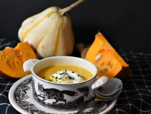Skål med græskarsuppe og friske græskar