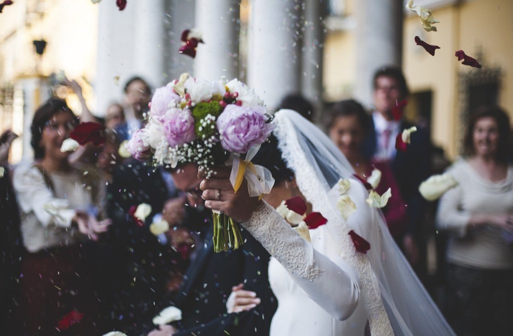 Brud med brudebuket i blomsterregn