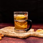 Varm krydret drink med citron på træbræt