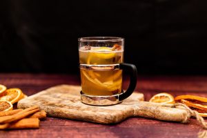 Varm krydret drink med citron på træbræt