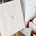 Elegant invitationskort med sløjfe og perle