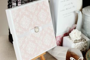 Elegant invitationskort med sløjfe og perle